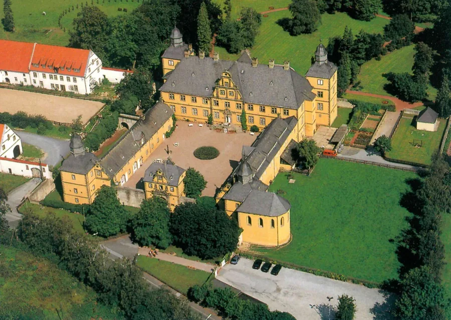 Farbiges Luftbild der gesamten Anlage mit Herrenhaus, Wirtschaftsgebäuden und Park